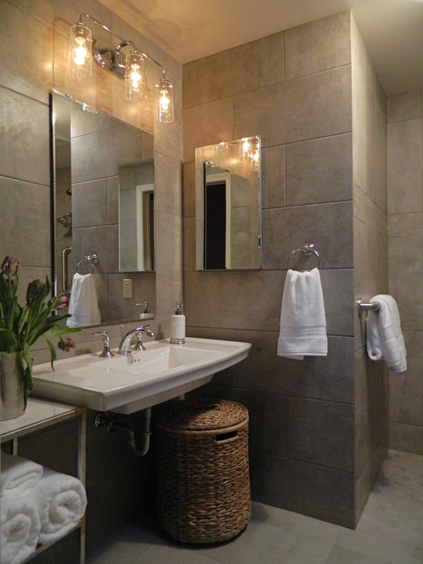 ada accessible bath with slip resistant porcelain tile, custom height vanity, heated floors and  dual purpose grab bars.